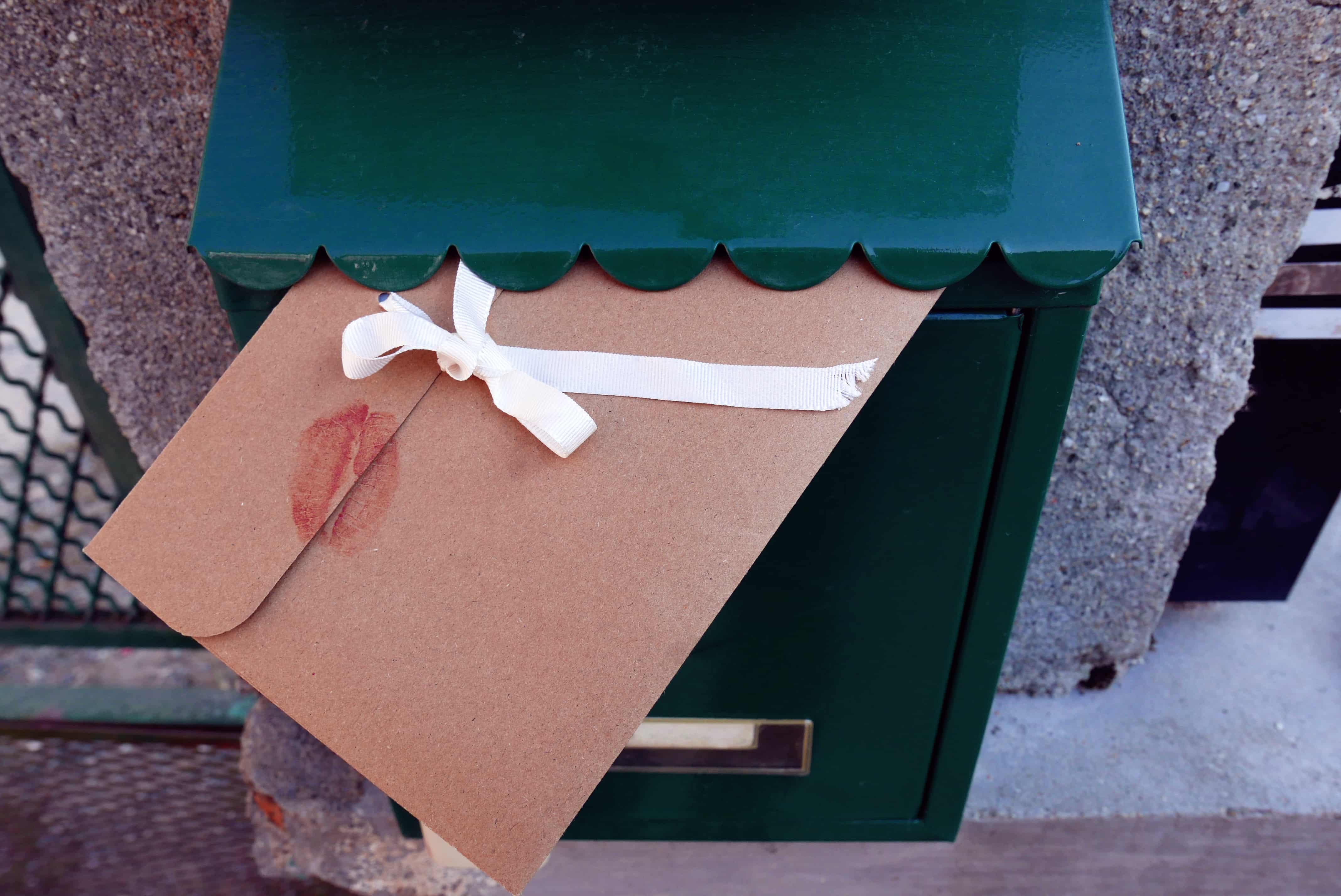 una lettera inserita in una cassetta per le lettere con sopra le impronte di labbra.