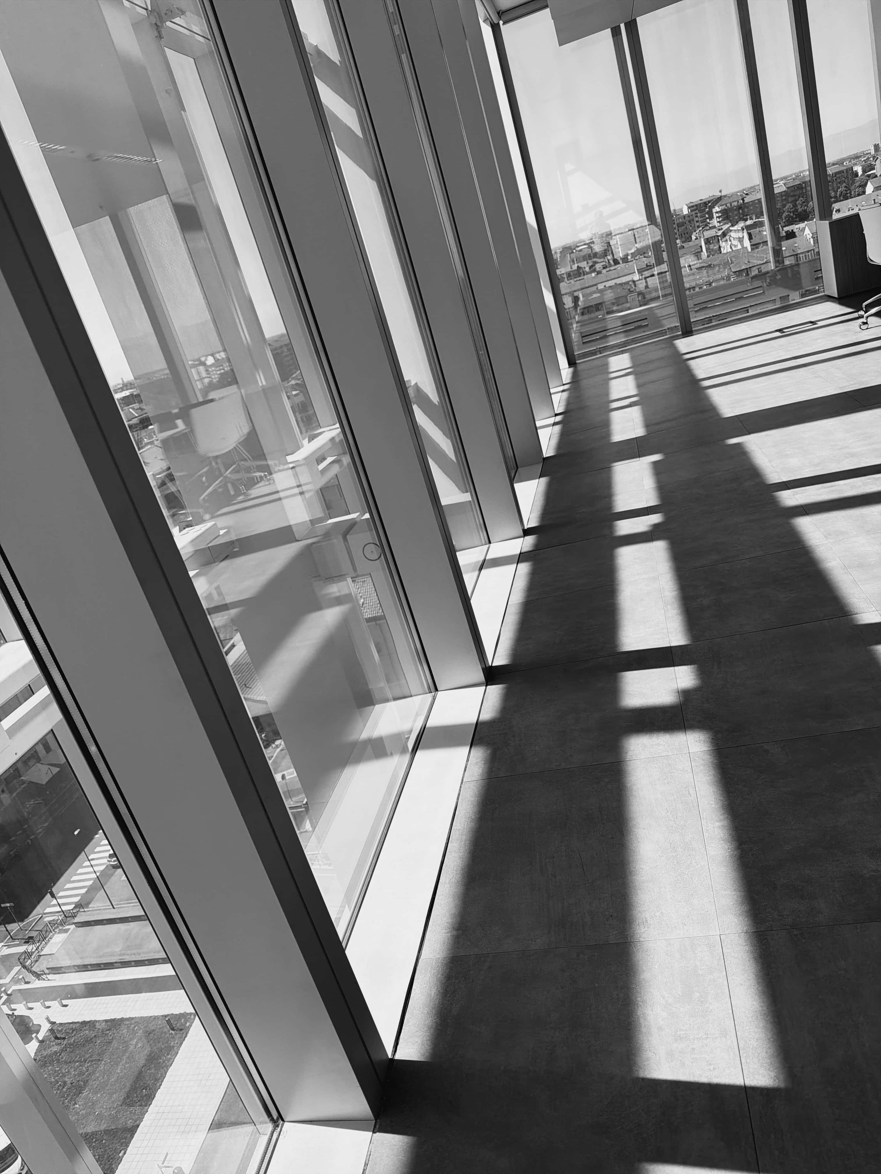 foto in bianco e nero di linee formate dall'ombra del sole all'interno di un palazzo